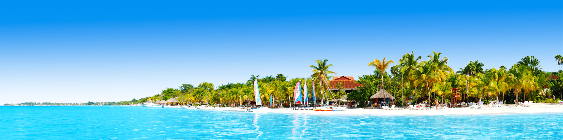 Helder zeewater aan het strand bij Jamaica omgeven met veel groen