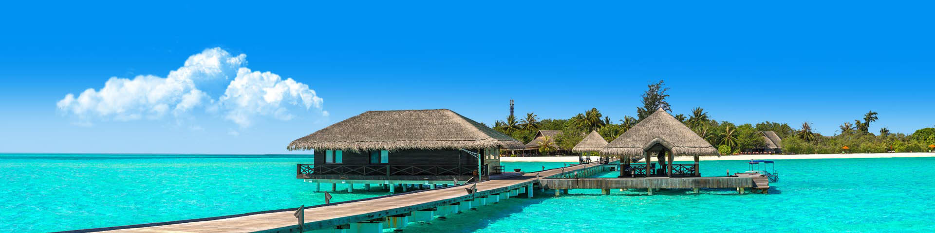 Luxe accommodatie gelegen in de helderblauwe zee met een strand op de achtergrond in de Malediven