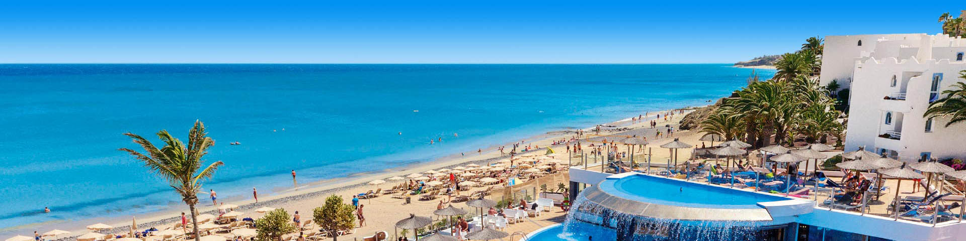 Uitzicht op het zandstrand en helderblauwe zee bij een Allsun hotel