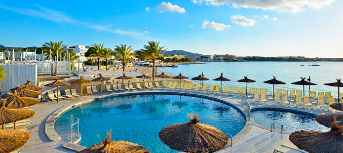 Een zwembad met ligbedden en parasols in een all in hotel