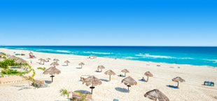 Ligbedden en parasols op het witte zandstrand bij Cancun in Mexico