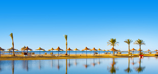 Strand in Hurghada in Egypte, vol met rieten parasols