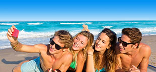 Jongeren maken selfie op strand in Egeïsche kust