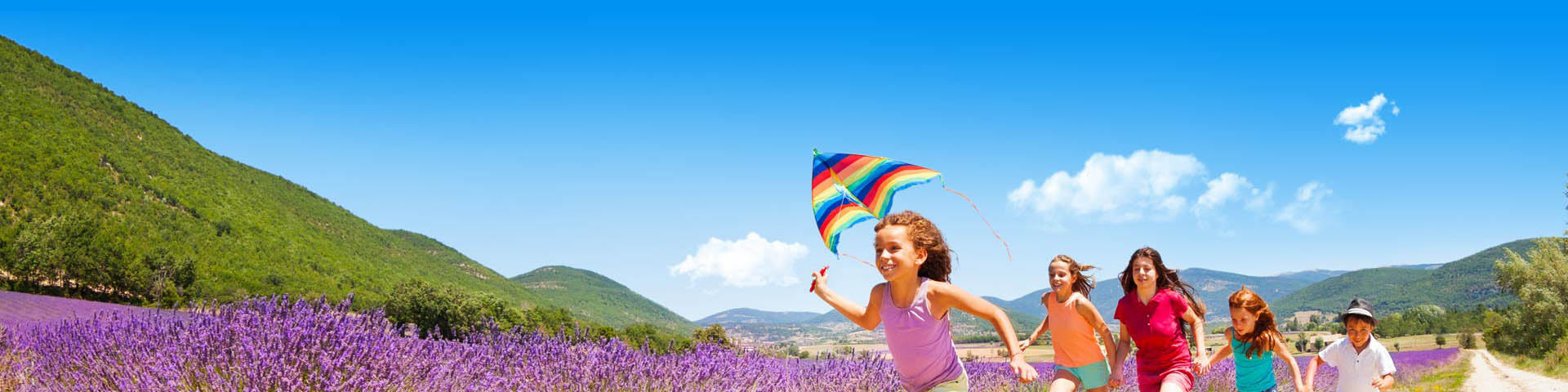 Rennende kinderen met een vlieger in de hand tijdens de kampeervakantie in een mooie omgeving