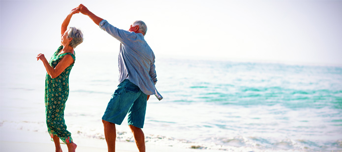 Senioren op het strand aan het dansen