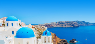 Witte gebouwen met blauwe daken en een blauwe zee in Santorini