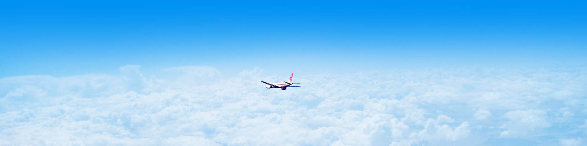 Vliegtuig vliegt boven de wolken in de hemelblauwe lucht