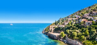 Blauwe zee met een dorpje in de bergen van Turkije