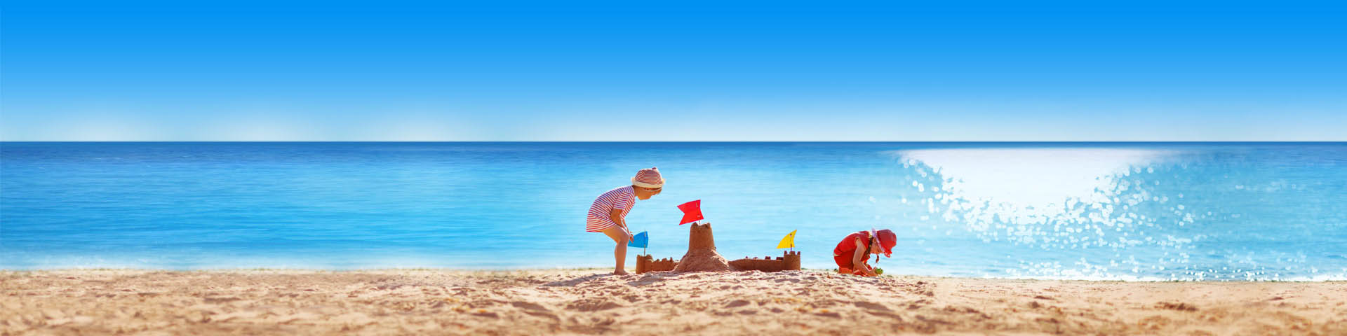 Kinderen spelen in het zand op het strand met zandkasteel