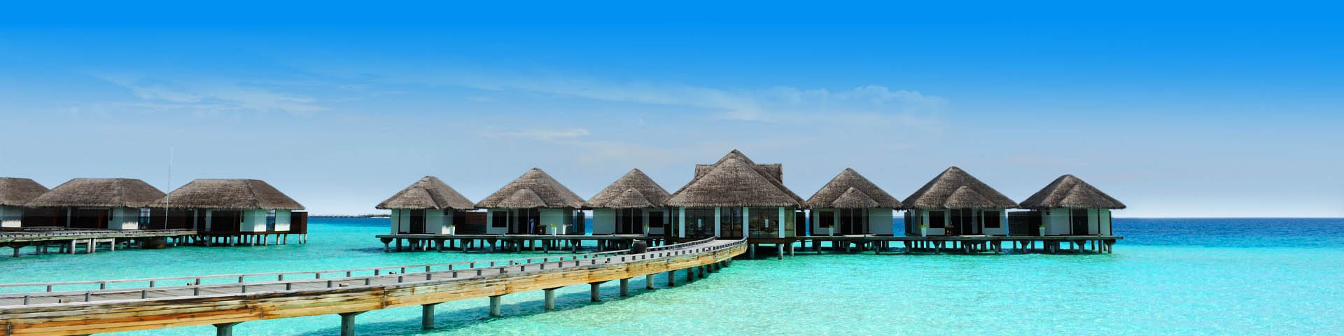 Waterbungalows aan een stijger gelegen in de helderblauwe zee van de Malediven