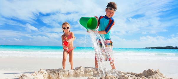 Twee kids in zwempak op het strand op vakantie