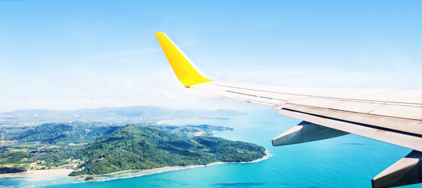 Vliegtuig vliegt boven de zee en vakantieland